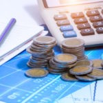 Double exposure of city and rows of coins for finance and banking concept
