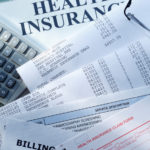 A health insurance claim form along with a couple of medical bills.