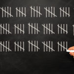 Picture of person counting real estate professional hours on a blackboard