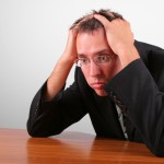 Picture of stressed out man holding head in his hands