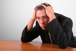 Picture of stressed out man holding head in his hands