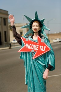 Picture of statute of liberty holding a sign that says income tax