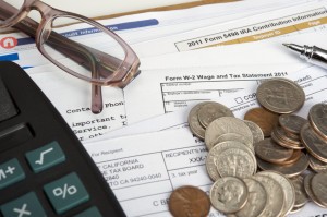 Tax forms, calculator, coingage and reading glasses.