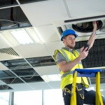 Picture of construction worker doing something with HVAC system