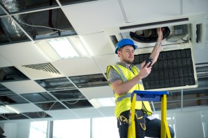 Picture of construction worker doing something with HVAC system