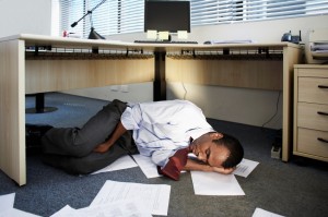Picture of accountant sleeping under his desk.