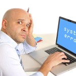 Picture of confused man sitting in front of computer that doesn't work.