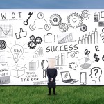 Picture of man standing in front of gigantic whiteboard.