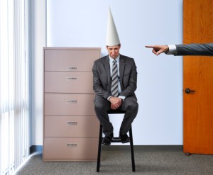 Business man wearing a dunce hat