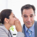 Picture of woman telling man a secret