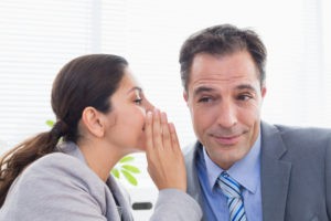 Picture of woman telling man a secret