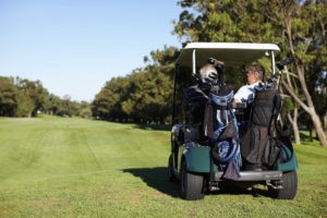 Picture of Golfing friends driving a golf car and going for a game of golf