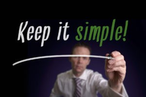 A businessman writing Keep It Simple on a screen. Business Concept.