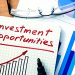 picture of Notepad with investment opportunities on office wooden table.