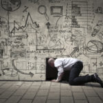 Picture of a man crawling into a small black hole, with illustrations on the wall.